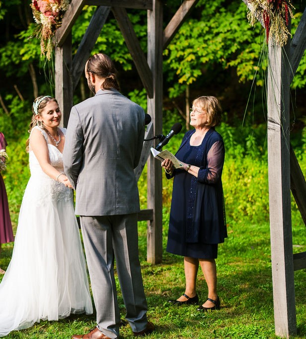 Rabbinic Pastor Nancy officiating a spiritual-but-not-religious wedding outside in a green field.
